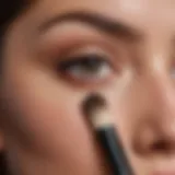 Concealer brush being used to apply makeup under eye area