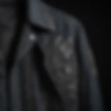 Close-up of intricate stitching details on the black denim jacket